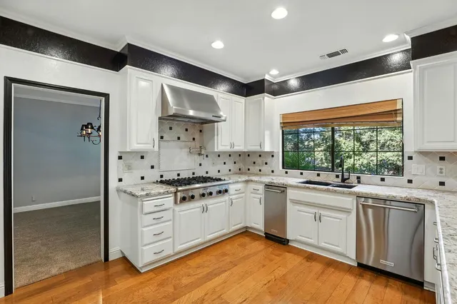 a kitchen with stainless steel appliances granite countertop a stove and a sink