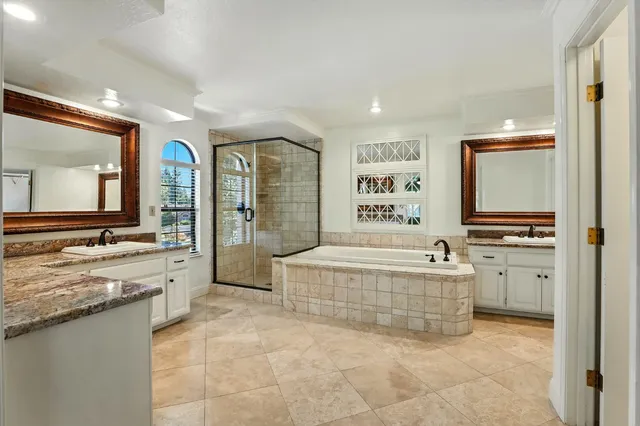 a spacious bathroom with a granite countertop tub sink and mirror