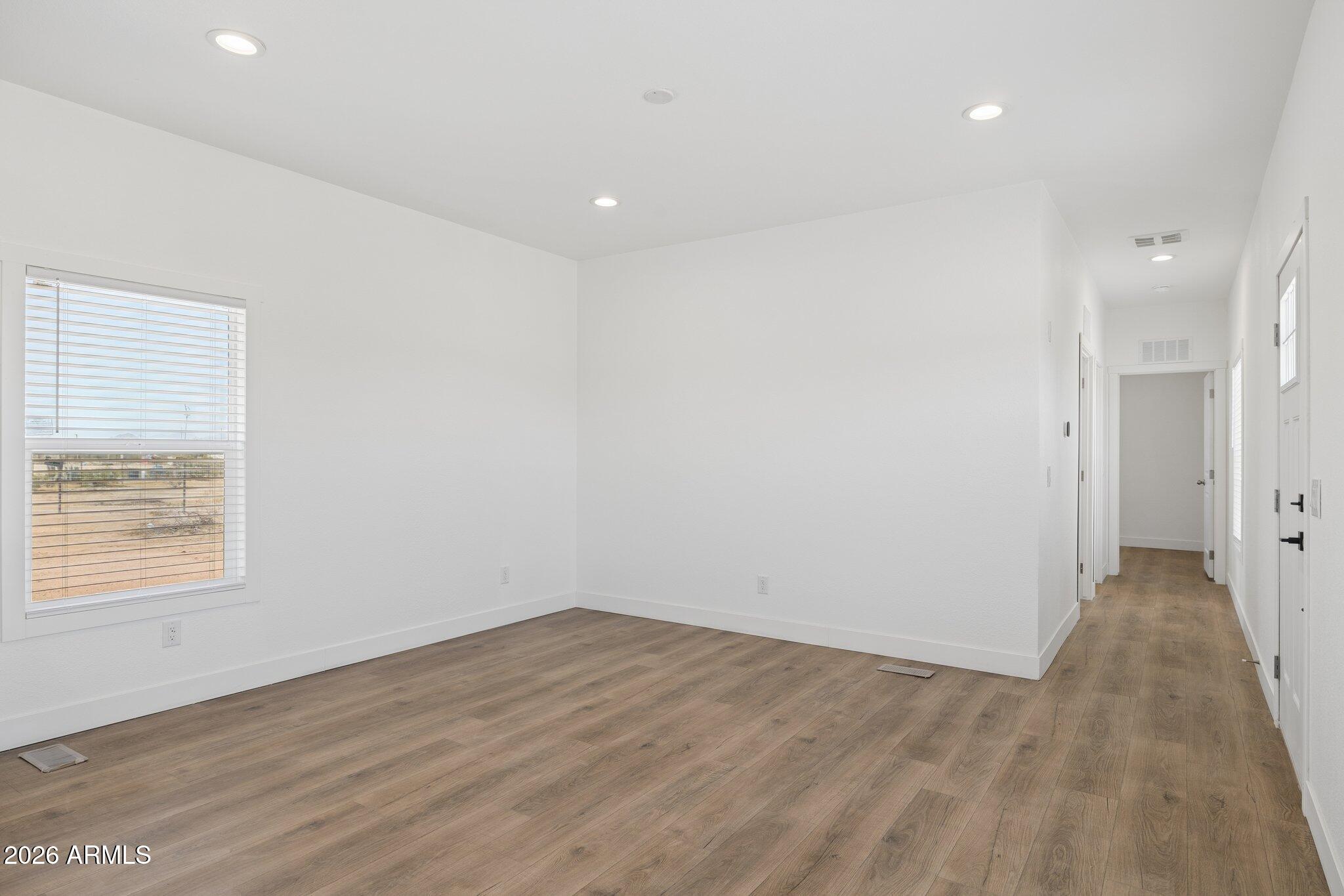 50044 West Century Road Maricopa, AZ 85139 - Photo 12 of 38 an empty room with wooden floor and windows