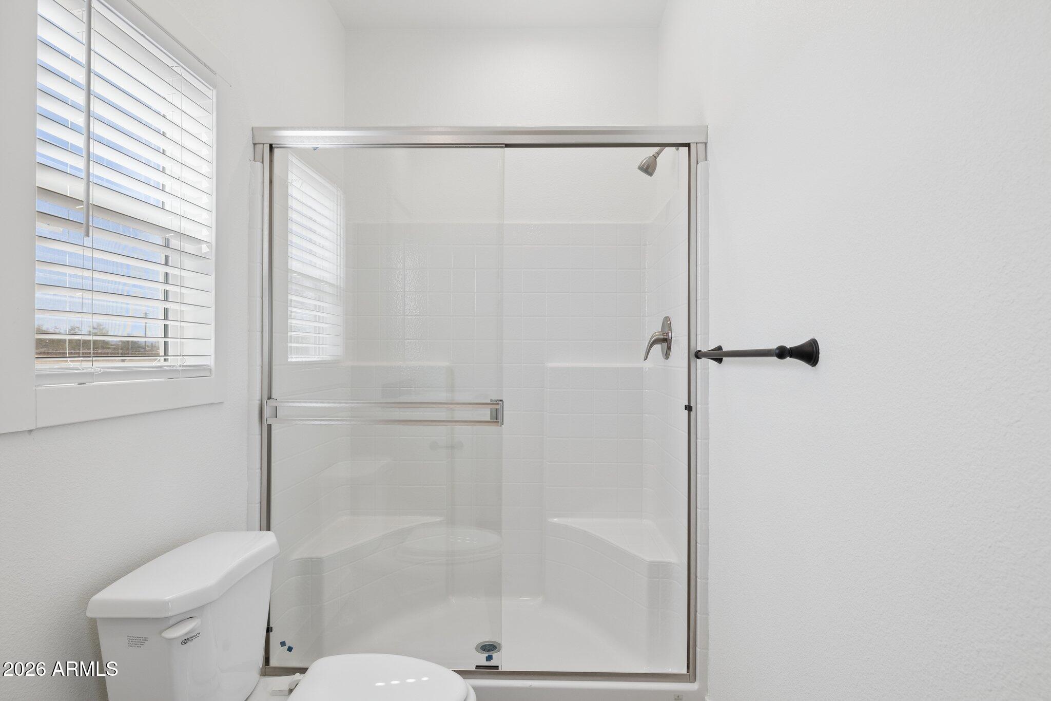 50044 West Century Road Maricopa, AZ 85139 - Photo 21 of 38 a bathroom with a shower a toilet and a window