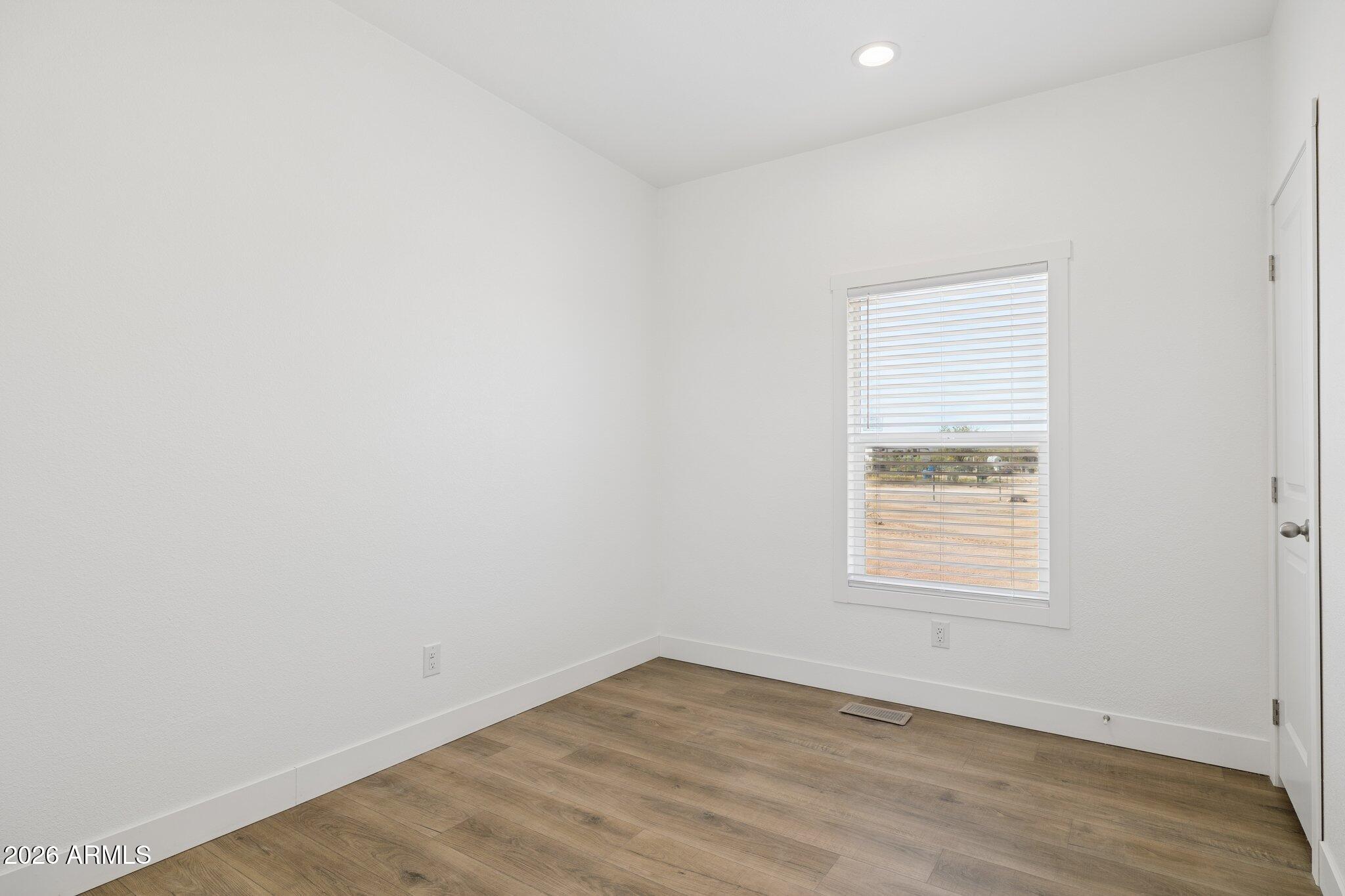 50044 West Century Road Maricopa, AZ 85139 - Photo 24 of 38 an empty room with wooden floor and windows