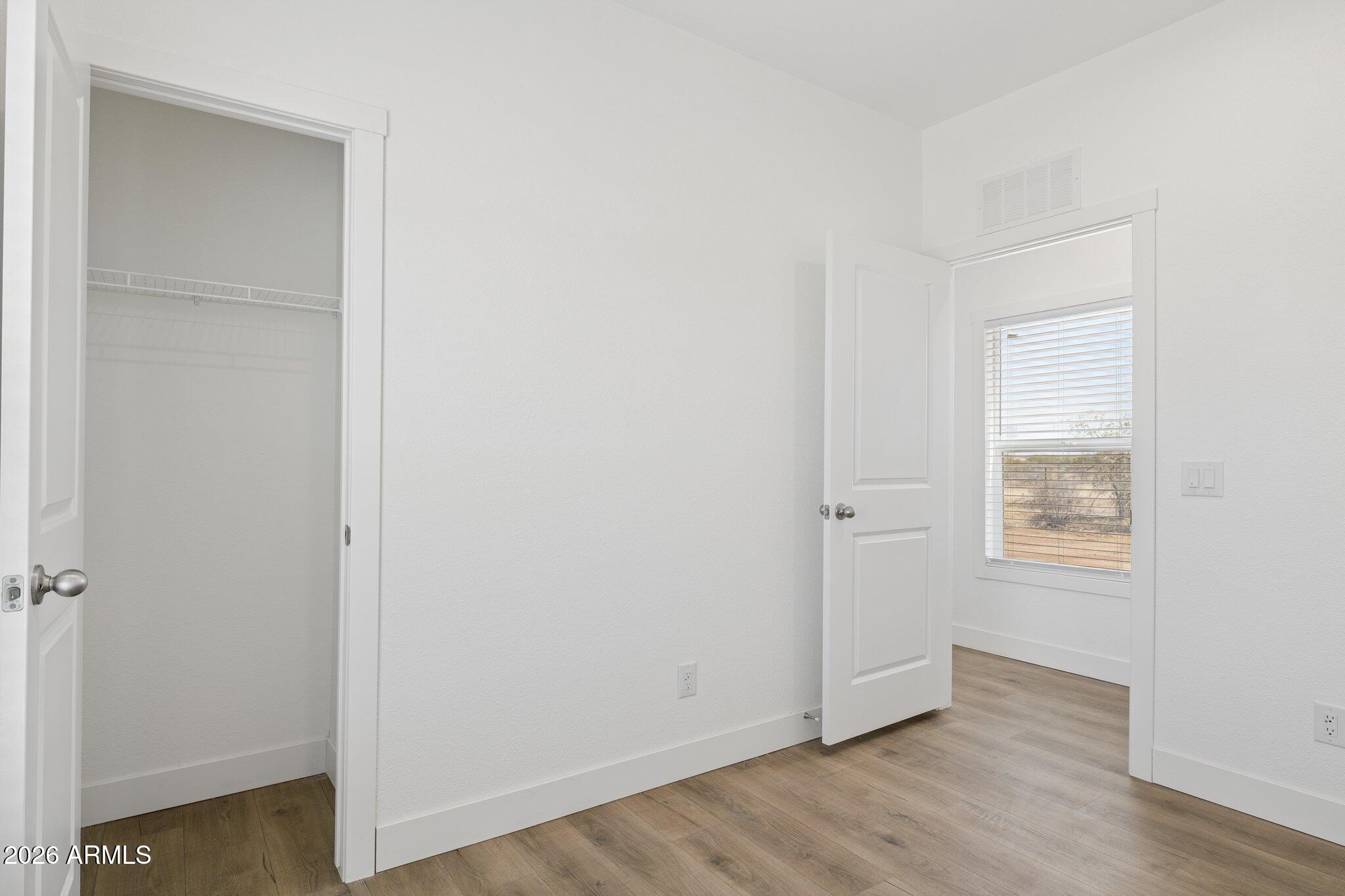 50044 West Century Road Maricopa, AZ 85139 - Photo 26 of 38 a view of an empty room with wooden floor and a window