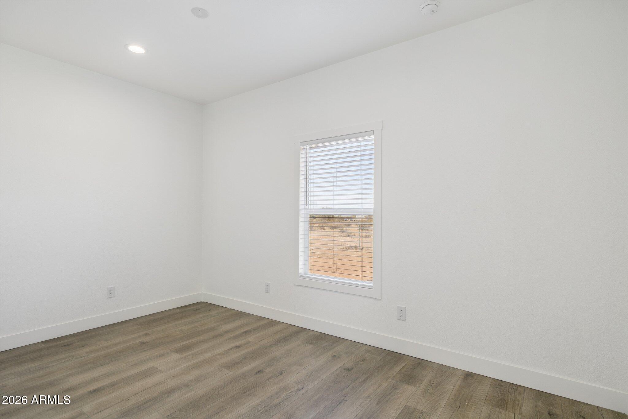 50044 West Century Road Maricopa, AZ 85139 - Photo 29 of 38 an empty room with wooden floor and windows
