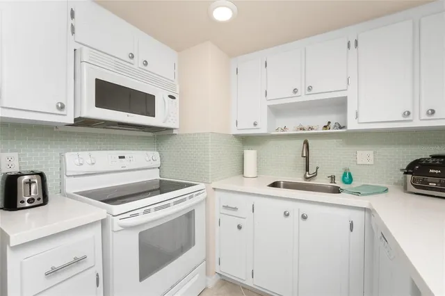 a kitchen with cabinets appliances a sink and a stove