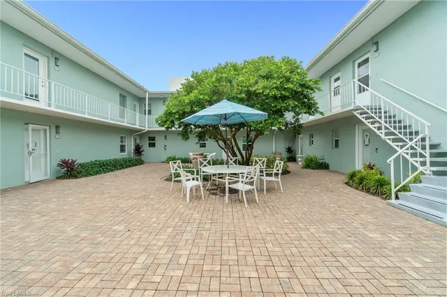 a view of a patio with a table and chairs under an umbrella
