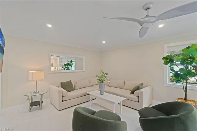 a living room with furniture a chandelier and a potted plant