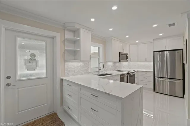 a kitchen with white cabinets and stainless steel appliances
