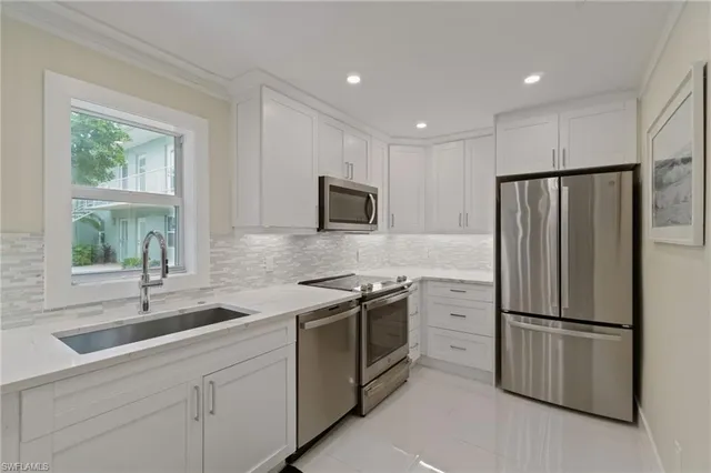 a kitchen with white cabinets and stainless steel appliances