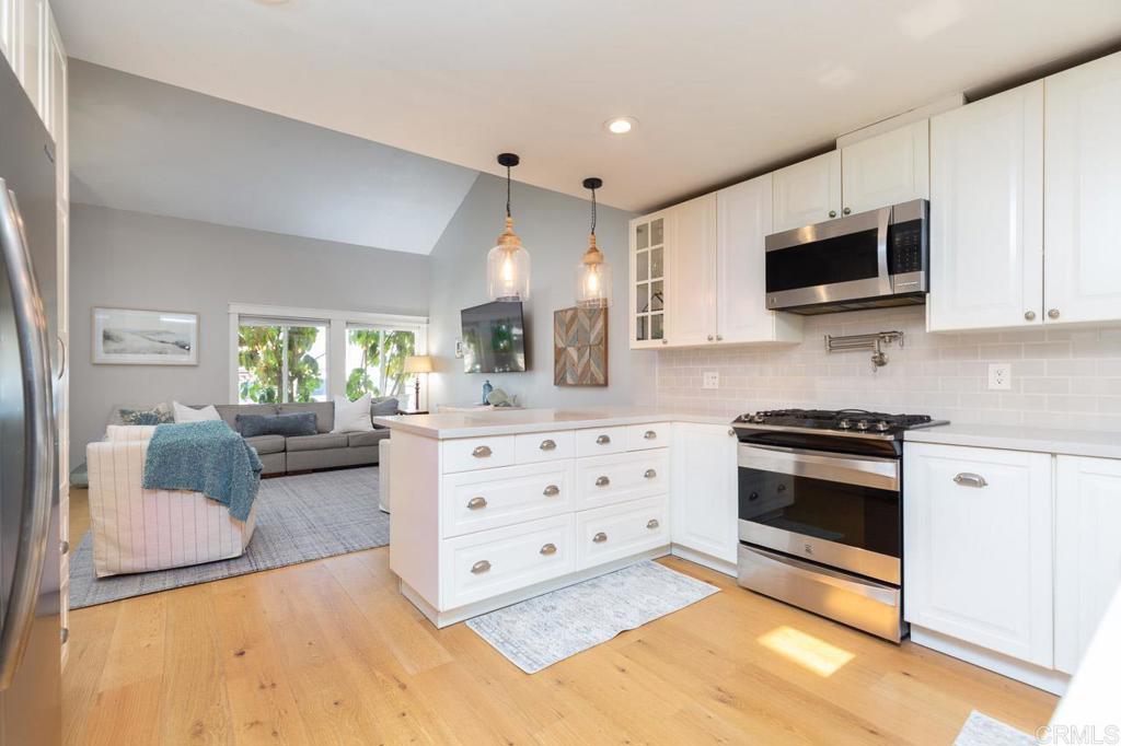 11061 Crystal Springs Road Santee, CA 92071 - Photo 12 of 30 a kitchen with stainless steel appliances kitchen island granite countertop a sink and a stove top oven with white cabinets