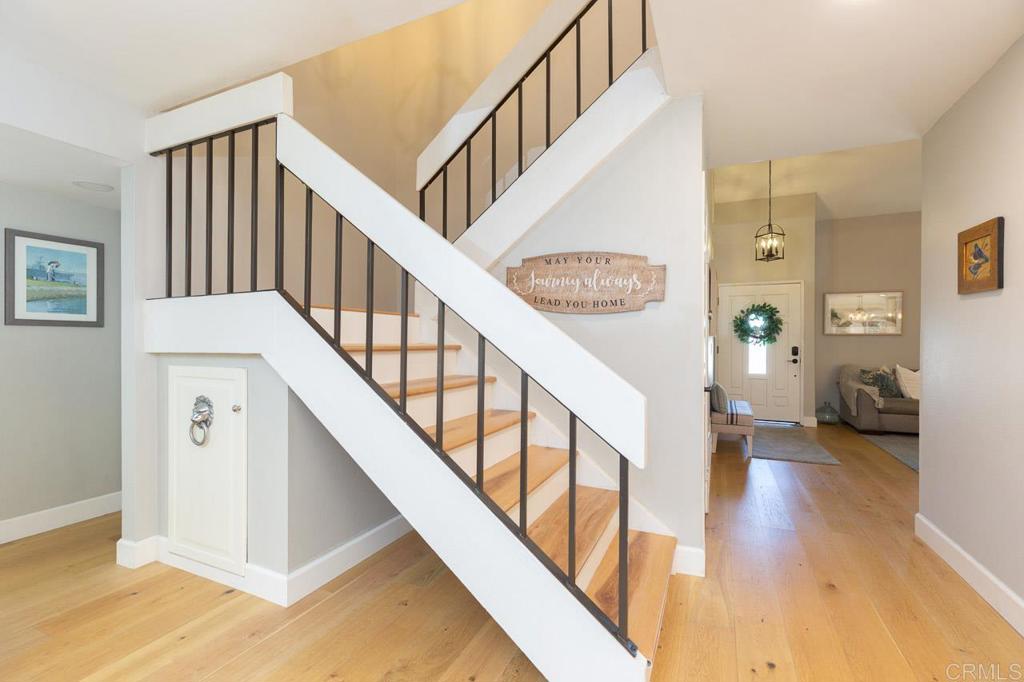 11061 Crystal Springs Road Santee, CA 92071 - Photo 10 of 30 a view of staircase with lots of frames on wall and wooden floor