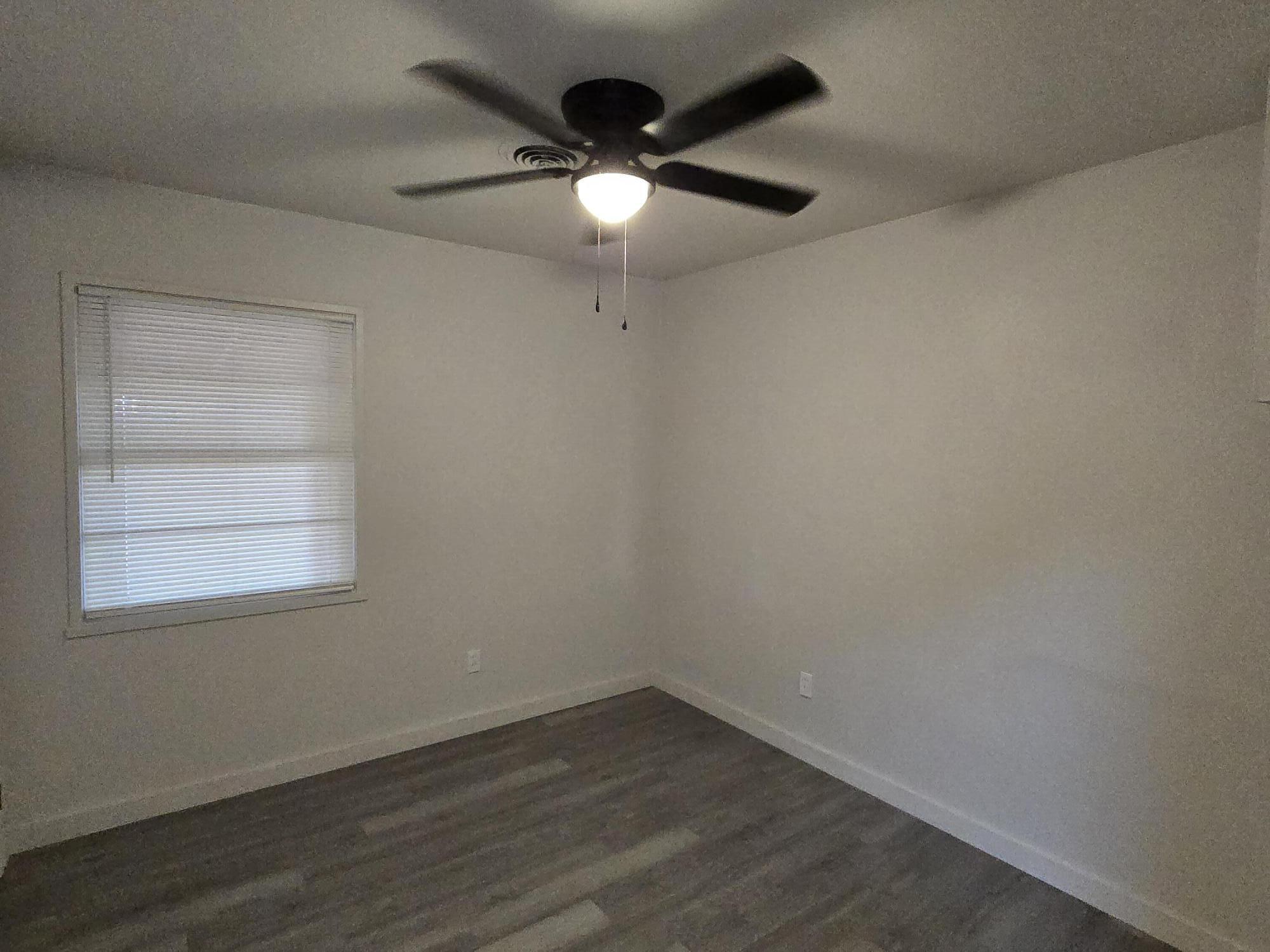 205 North 21st Street Lamesa, TX 79331 - Photo 11 of 14 an empty room with wooden floor and windows