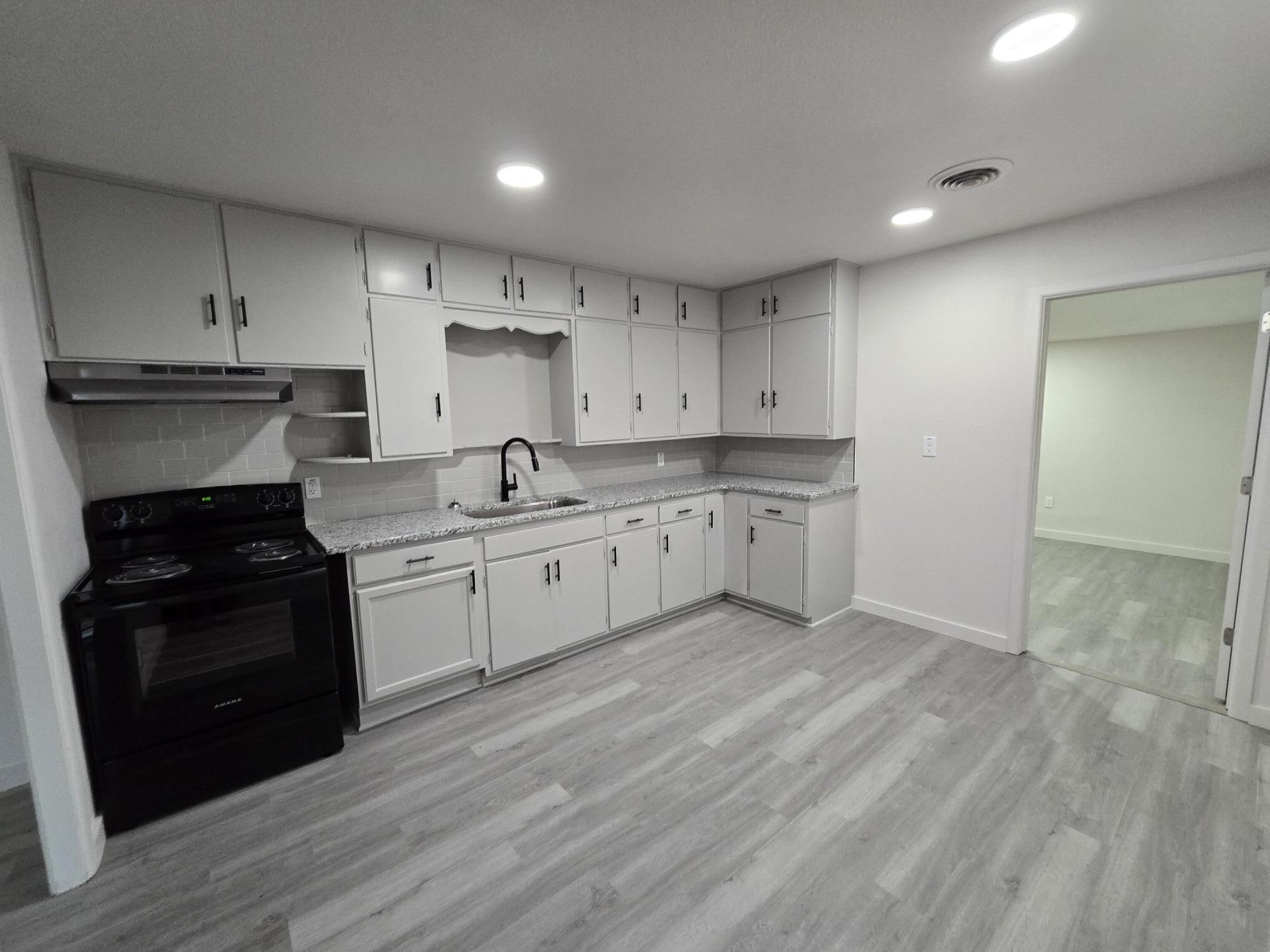 205 North 21st Street Lamesa, TX 79331 - Photo 3 of 14 a kitchen with a sink a stove and cabinets
