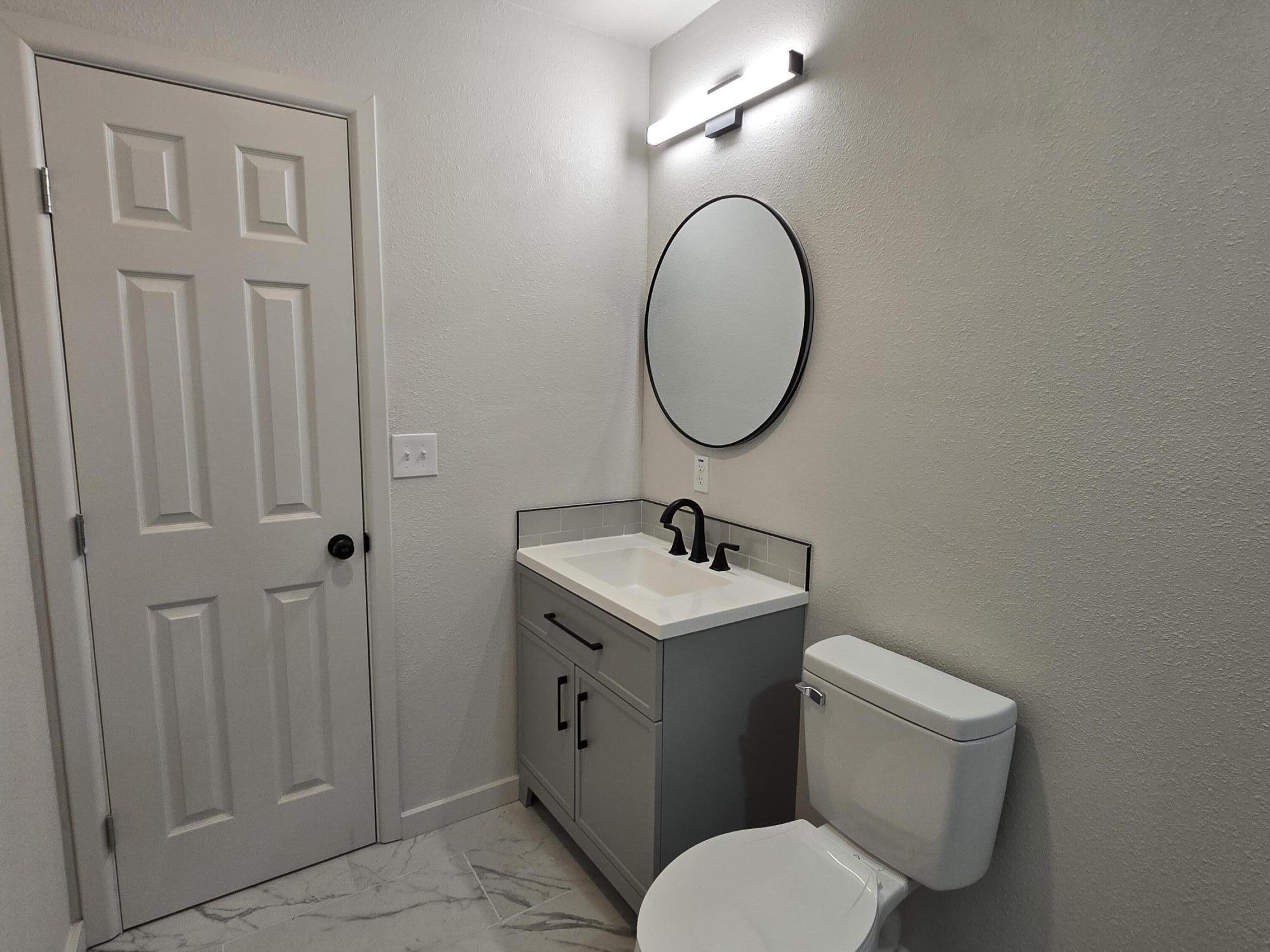 205 North 21st Street Lamesa, TX 79331 - Photo 7 of 14 a bathroom with a toilet sink and mirror