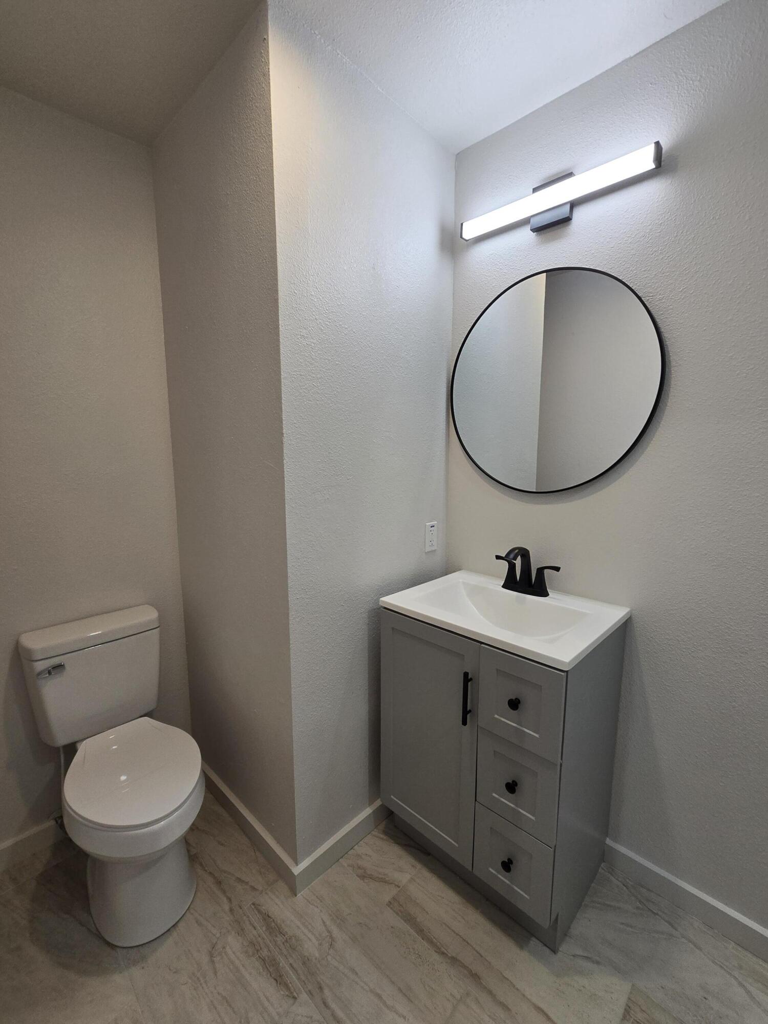 205 North 21st Street Lamesa, TX 79331 - Photo 9 of 14 a bathroom with a toilet a sink and mirror