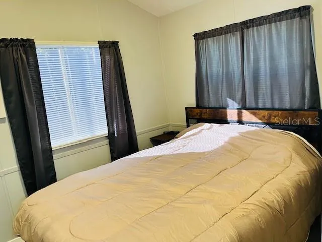 a bed sitting in a bedroom next to a window