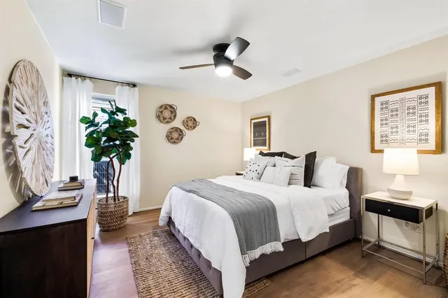 a bedroom with a large bed and a potted plant