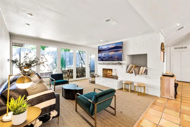 a living room with fireplace furniture and a large window