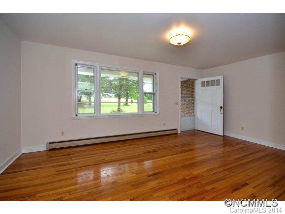 517 Tugaloo Road Landrum, SC 29356 - Photo 3 of 14 an empty room with wooden floor and windows