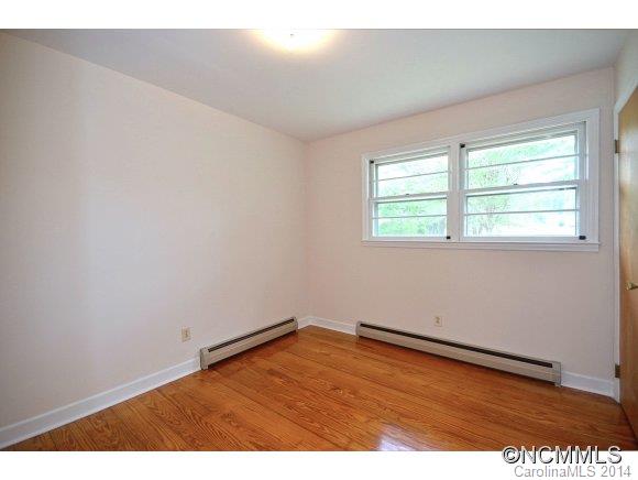 517 Tugaloo Road Landrum, SC 29356 - Photo 9 of 14 an empty room with wooden floor and windows