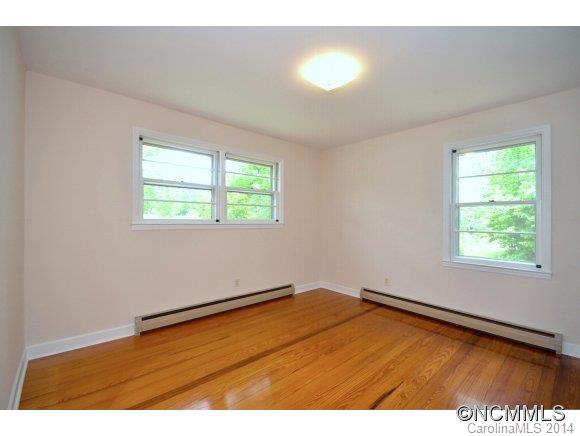 517 Tugaloo Road Landrum, SC 29356 - Photo 10 of 14 an empty room with wooden floor and windows