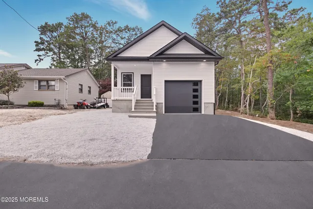 a view of a house with a yard and large tree