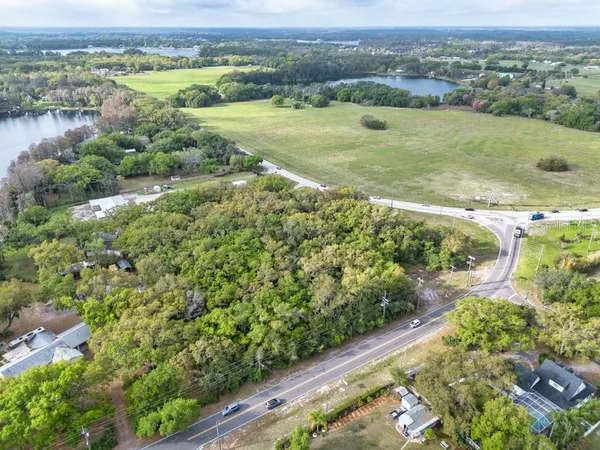 an aerial view of a houses with a yard and lake view