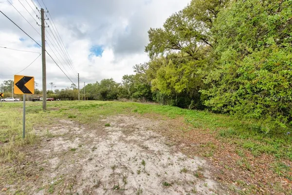 a view of a green field with wooden fence