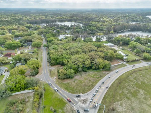 an aerial view of a residential houses with outdoor space and trees