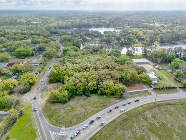 an aerial view of residential houses with outdoor space and trees