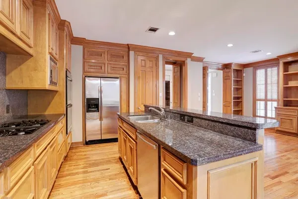 a kitchen with stainless steel appliances granite countertop a sink and a counter space