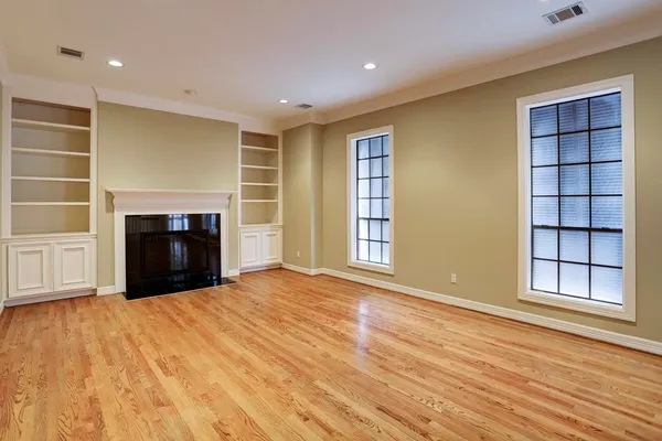 a view of an empty room with a fireplace and a window