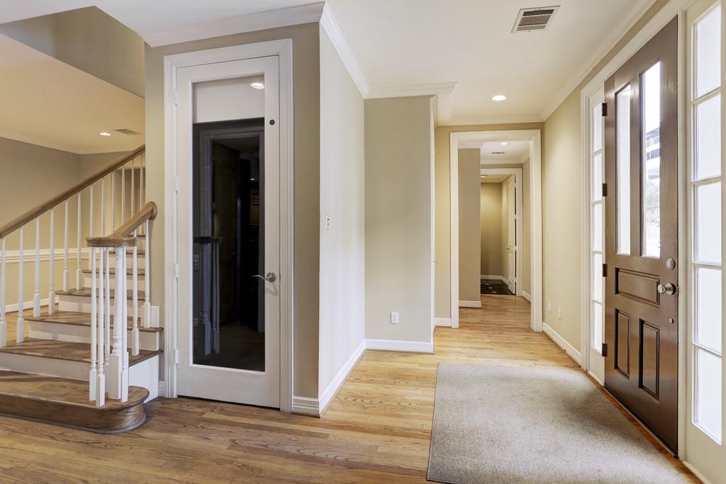 516 South Post Oak Lane, Unit 7 Houston, TX 77056 - Photo 7 of 8 a view of a hallway with wooden floor and staircase