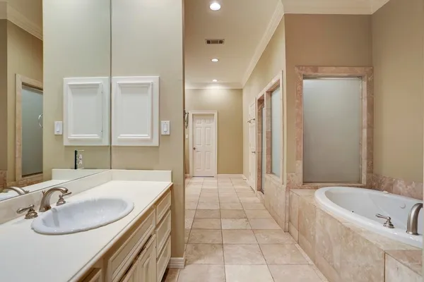 a bathroom with a granite countertop sink a bathtub and a mirror
