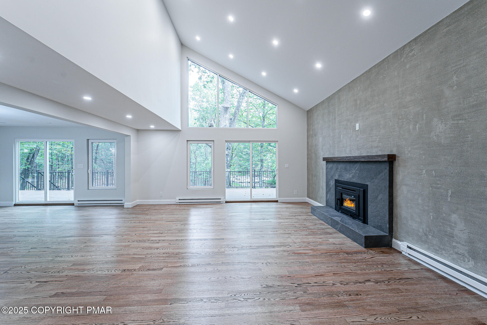 5806 Decker Road Bushkill, PA 18324 - Photo 16 of 76 an empty room with wooden floor fireplace cabinet and windows