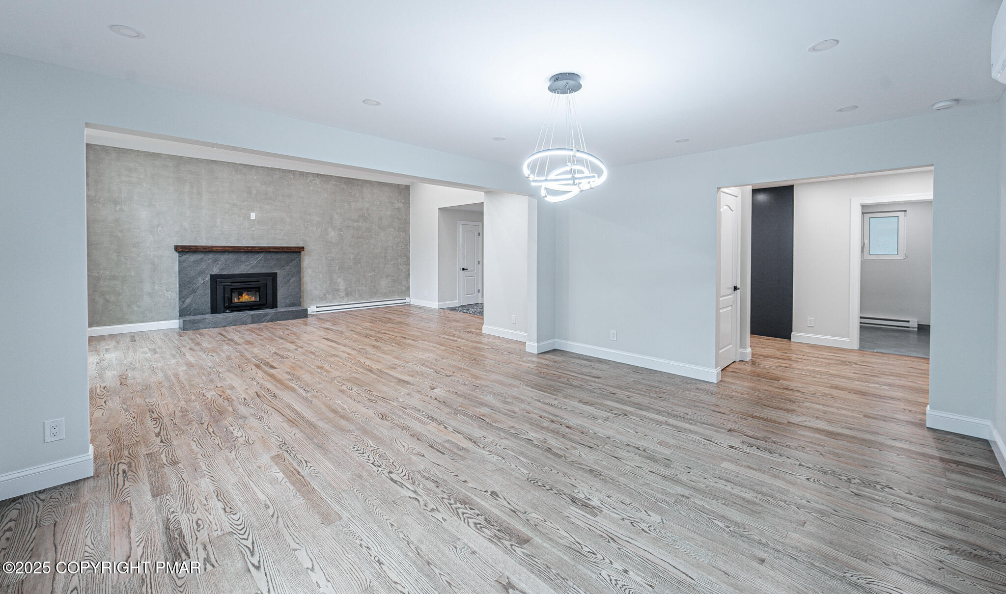 5806 Decker Road Bushkill, PA 18324 - Photo 21 of 76 an empty room with wooden floor fireplace and windows