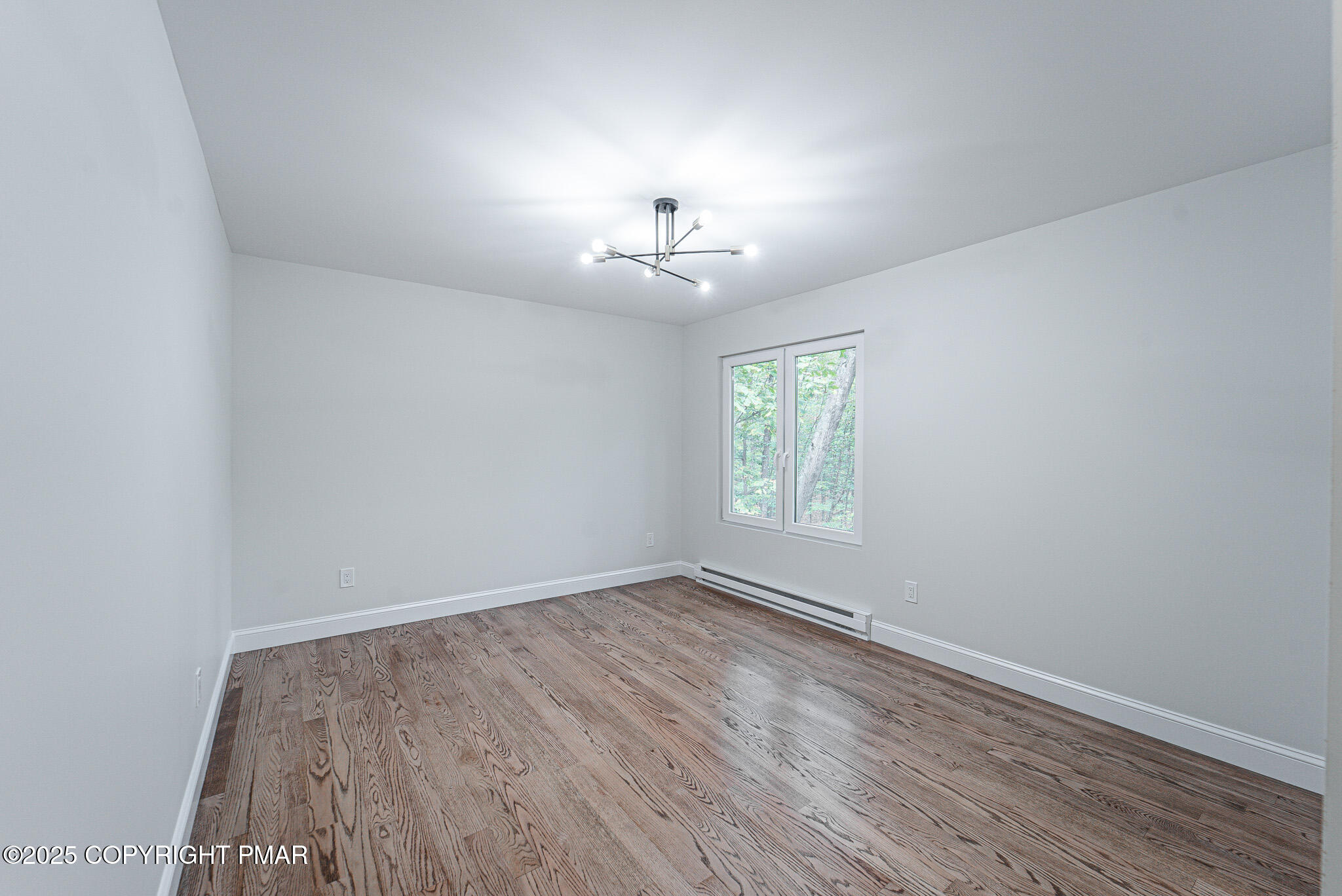 5806 Decker Road Bushkill, PA 18324 - Photo 46 of 76 an empty room with wooden floor chandelier fan and windows
