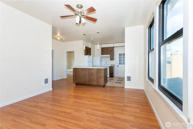 a view of a livingroom with furniture wooden floor and a ceiling fan