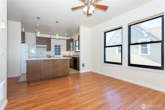 a view of kitchen with stainless steel appliances granite countertop a stove top oven a sink with wooden floors