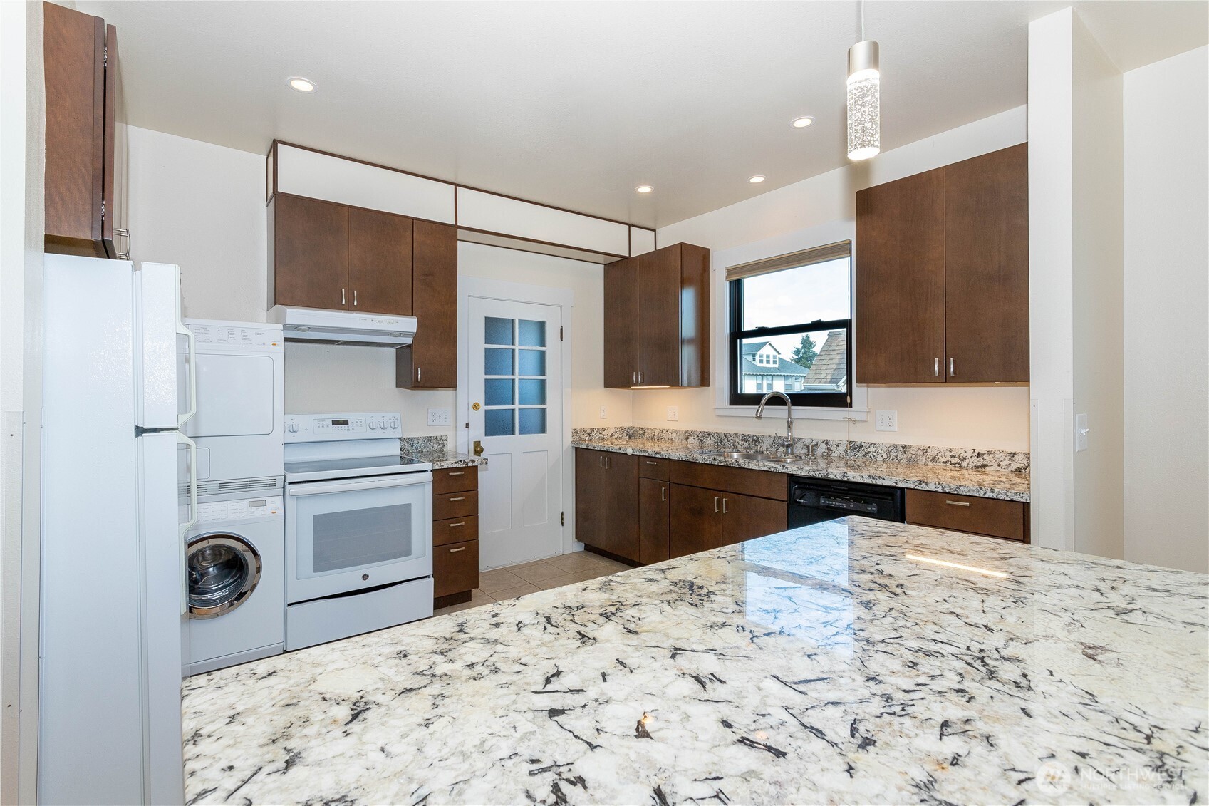 3010 East Spruce Street Seattle, WA 98122 - Photo 9 of 20 a kitchen with stainless steel appliances kitchen island granite countertop a sink and a stove top oven