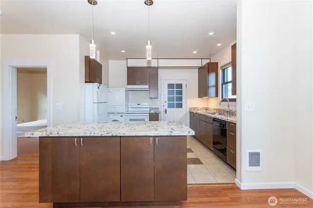 a large kitchen with kitchen island a sink stainless steel appliances and cabinets
