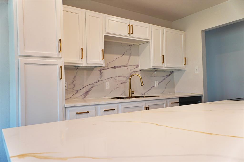6357 Cascade Circle Watauga, TX 76148 - Photo 6 of 22 a kitchen with granite countertop white cabinets and white appliances