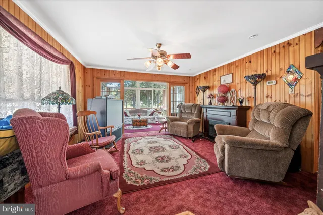 a living room with furniture a flat screen tv and a large window