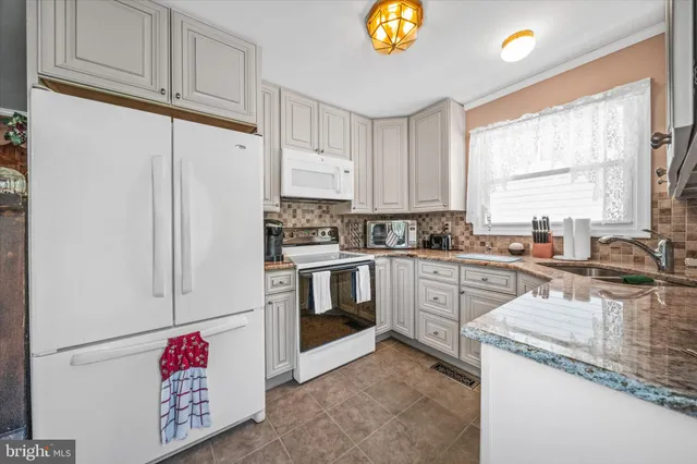a kitchen with granite countertop cabinets stainless steel appliances and a sink