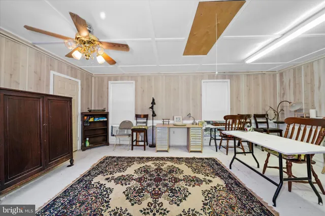 a living room with furniture a rug and white walls
