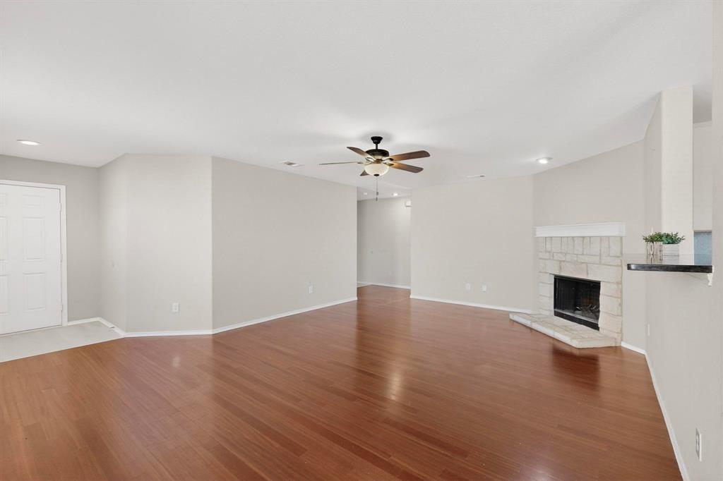 303 Laurel Lane Fate, TX 75087 - Photo 11 of 33 a view of empty room with wooden floor and fireplace