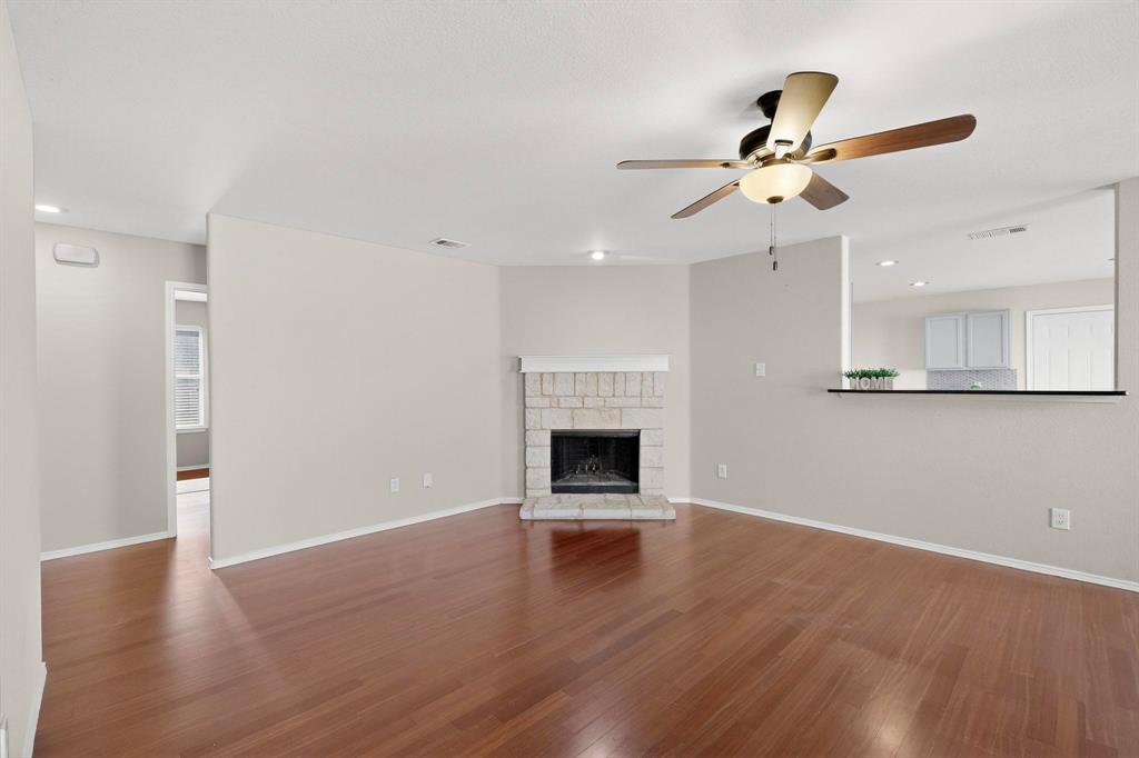 303 Laurel Lane Fate, TX 75087 - Photo 12 of 33 a view of an empty room with wooden floor and a fireplace