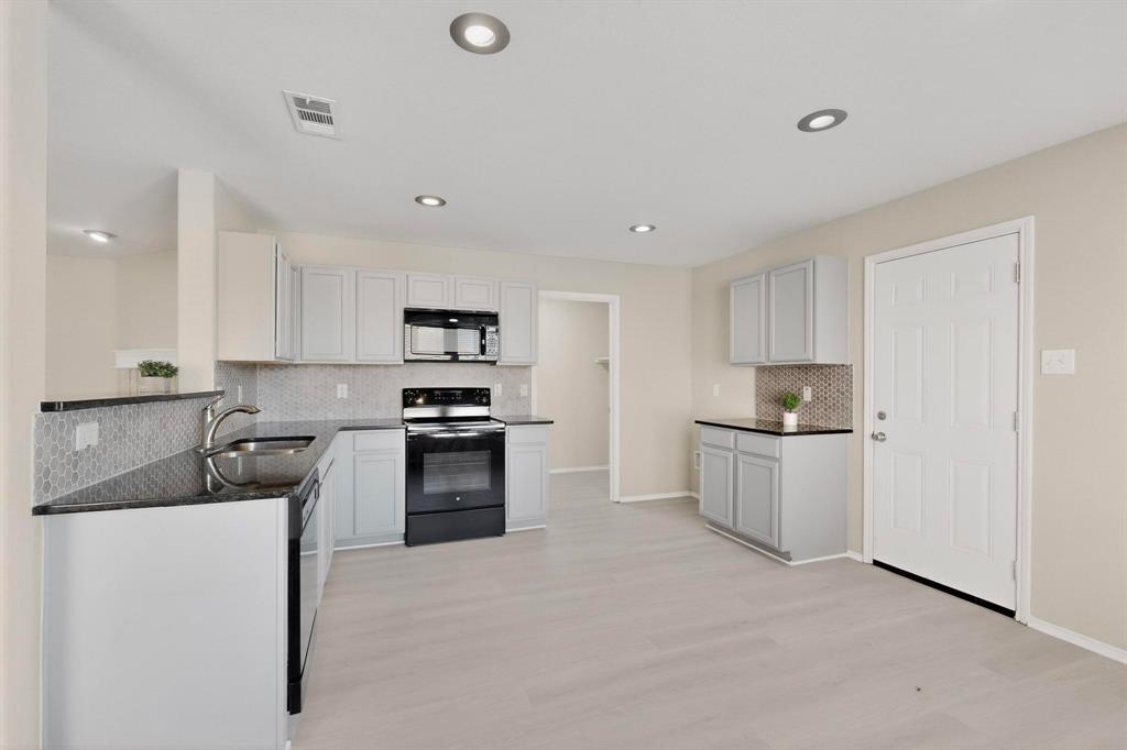 303 Laurel Lane Fate, TX 75087 - Photo 13 of 33 a kitchen with a sink white cabinets and stainless steel appliances