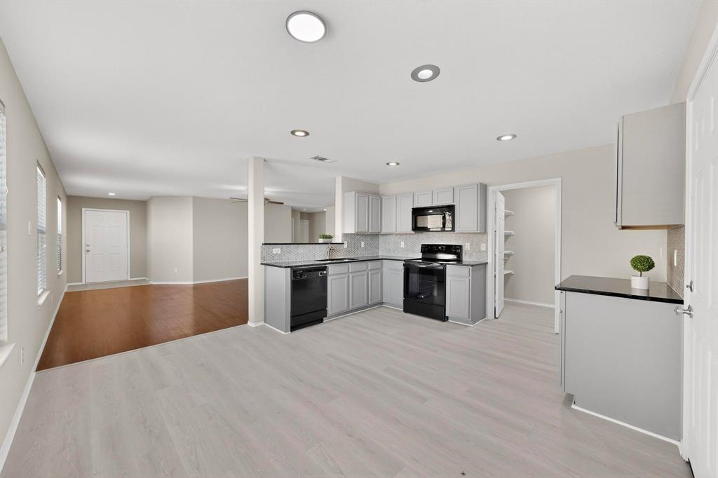 303 Laurel Lane Fate, TX 75087 - Photo 15 of 33 a kitchen with granite countertop a sink and stainless steel appliances