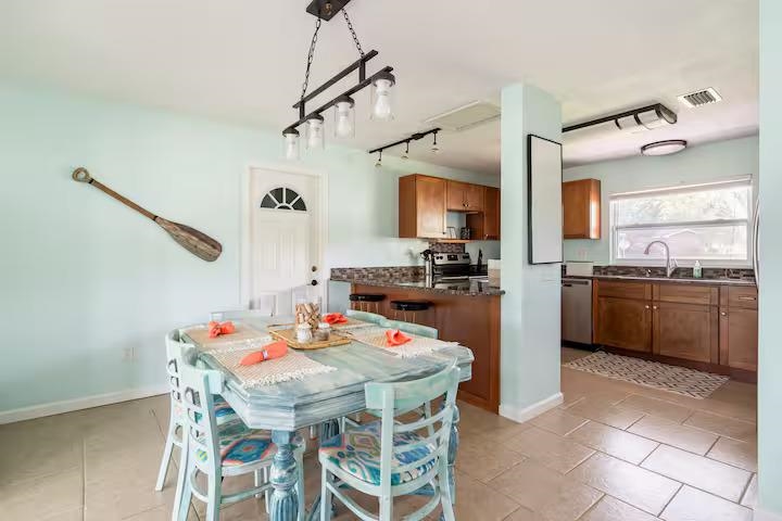 238 Lily Road St. Augustine Shores, FL 32086 - Photo 9 of 22 a open kitchen with a refrigerator a sink dishwasher a dining table and chairs with wooden floor
