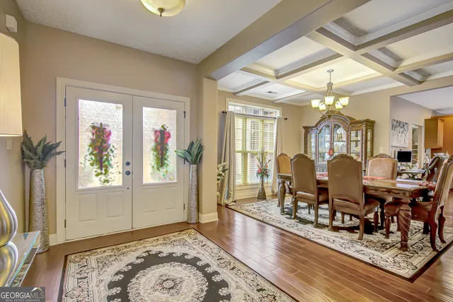a kitchen with stainless steel appliances kitchen island granite countertop a table chairs and a wooden floor